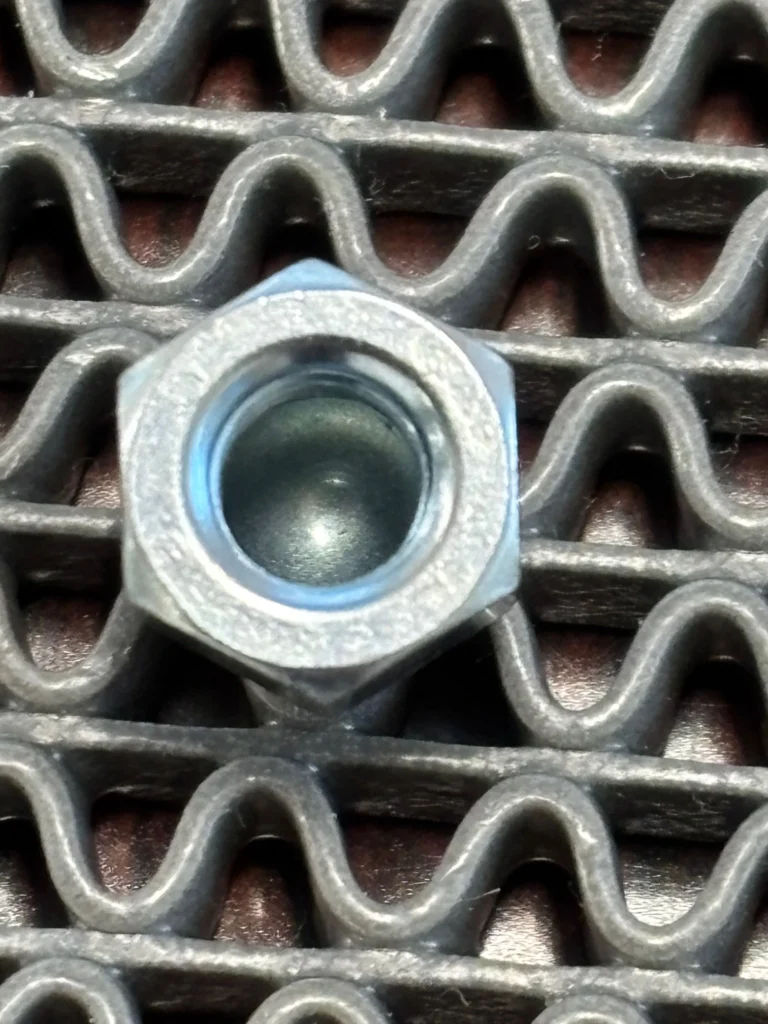 袋ナットの内側拡大写真。ネジ山から底のドーム部分まで光沢のあるメッキが乗っている様子。